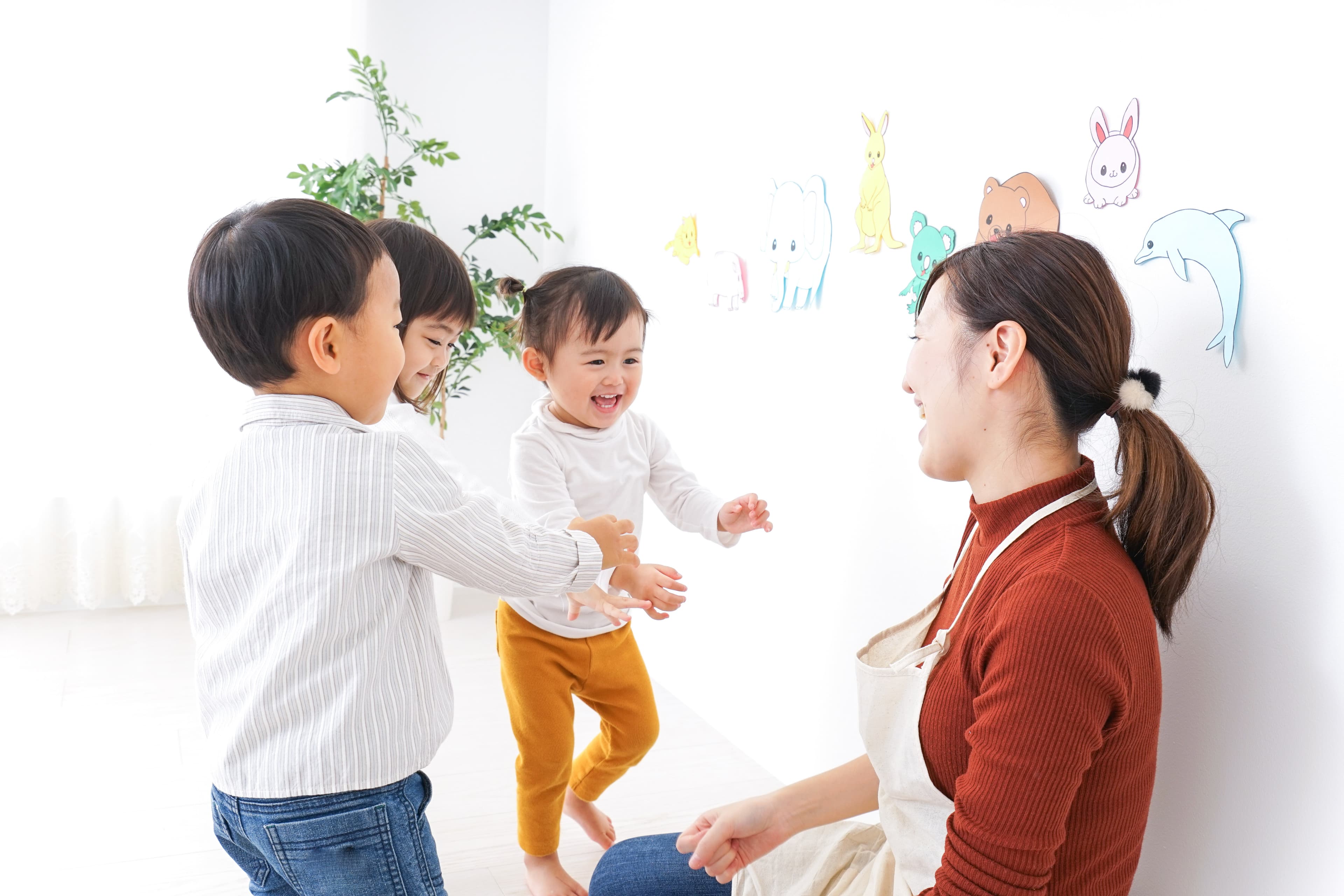 Three smiling children interacting with a caregiver