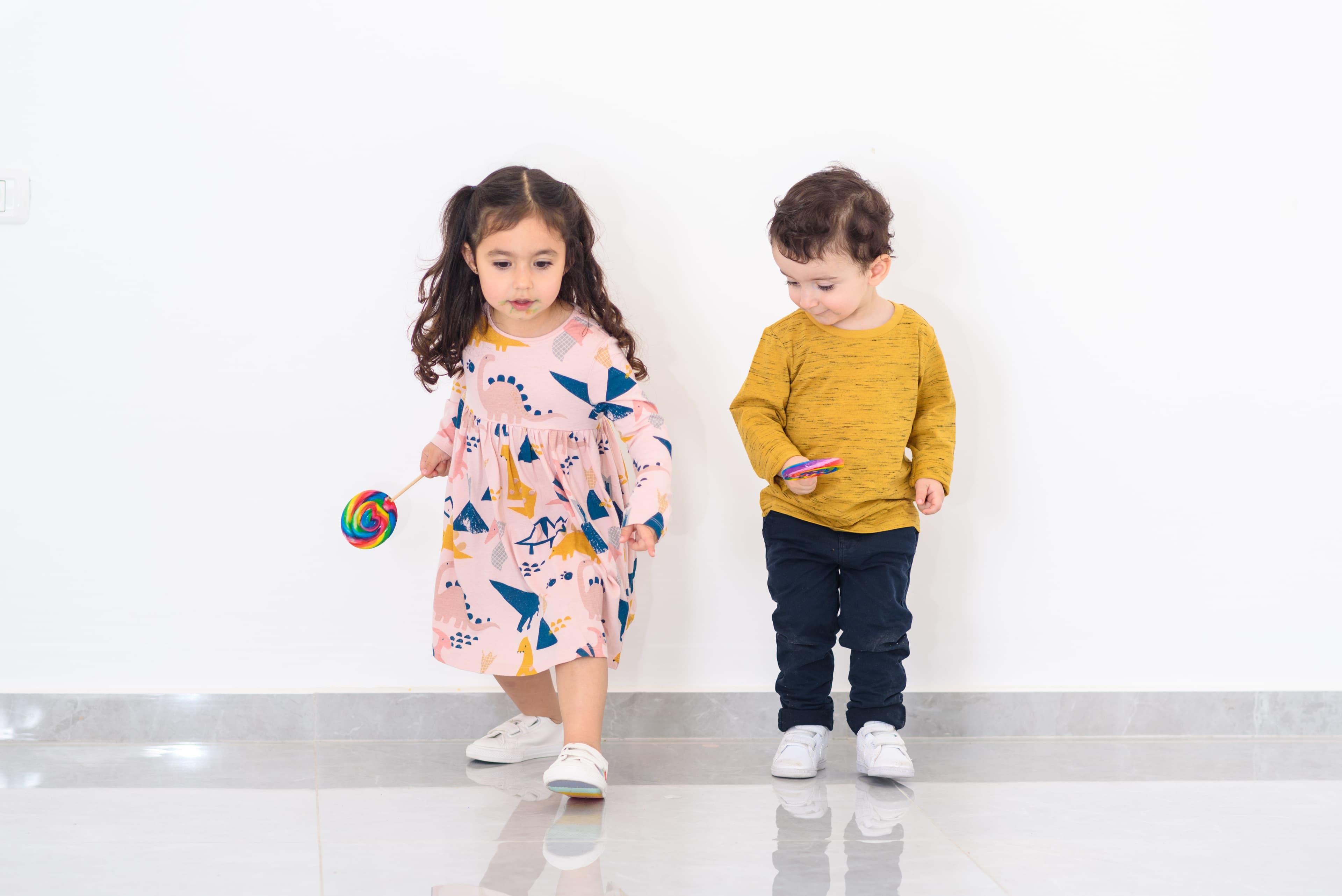 Two children holding very large lolipops