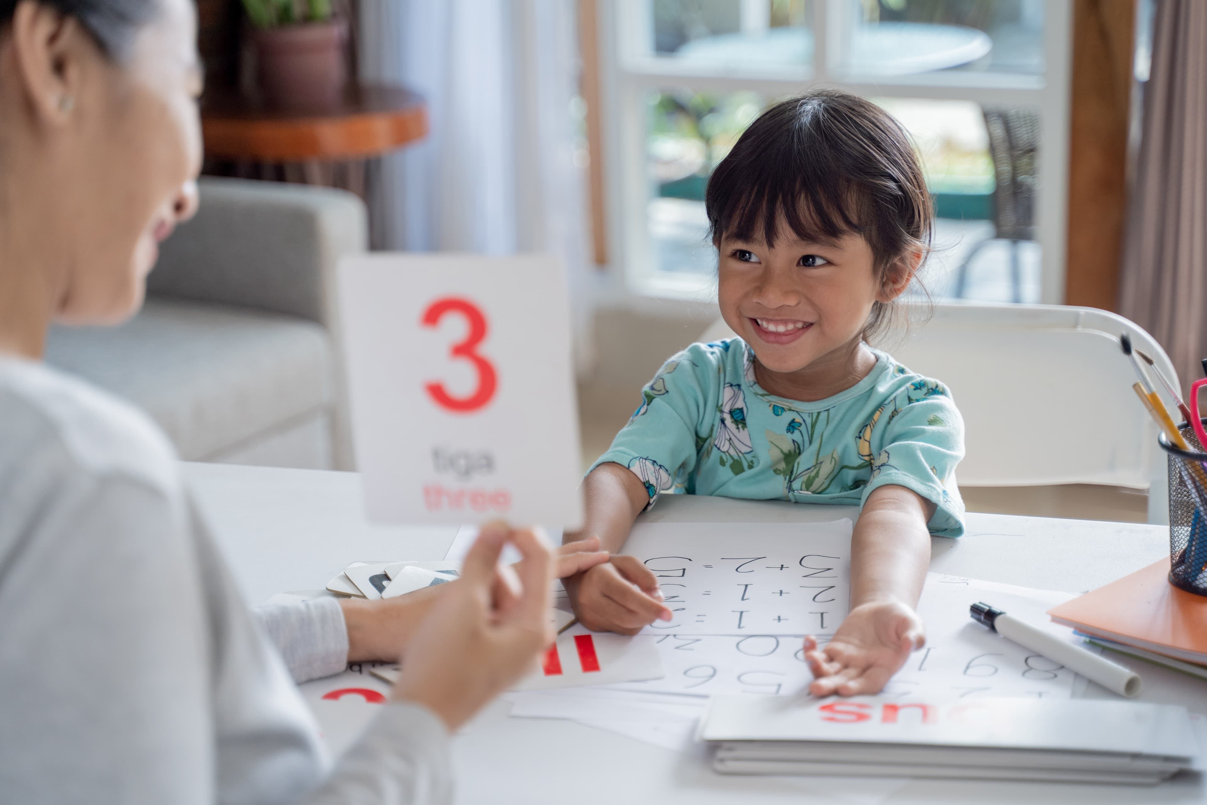 happy kid learning and studying together with parent at home
