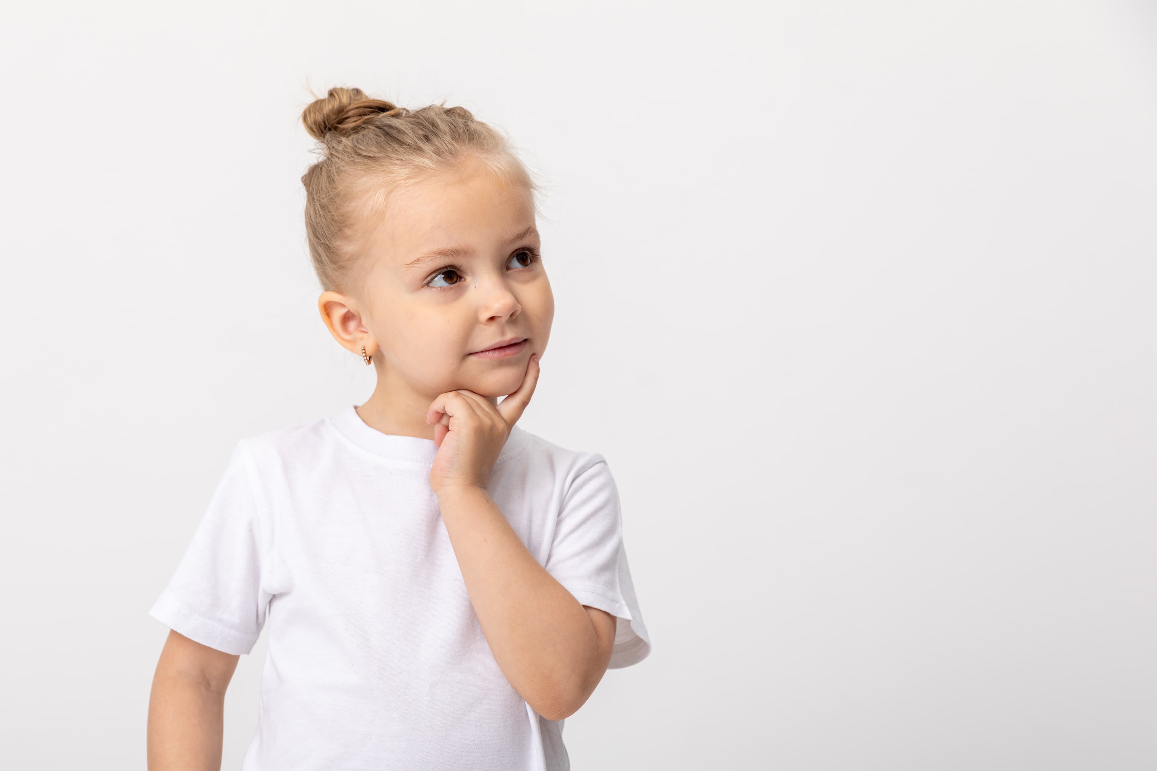 A girl looking up and to the right against a light gray background