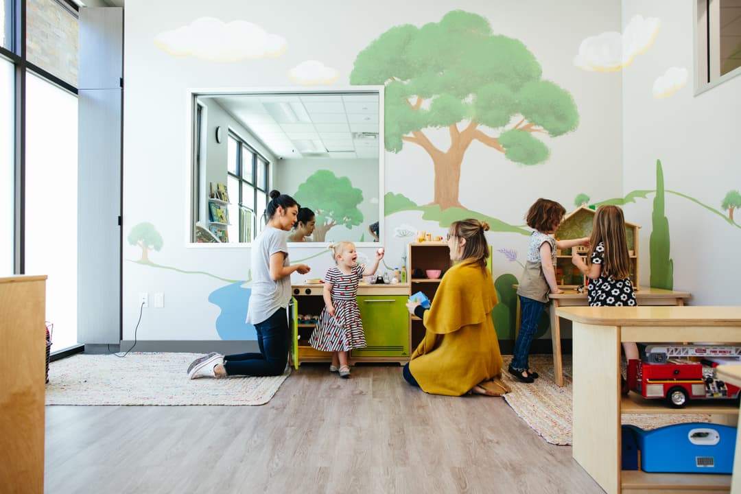 A group of children and teachers interacting within a classroom
