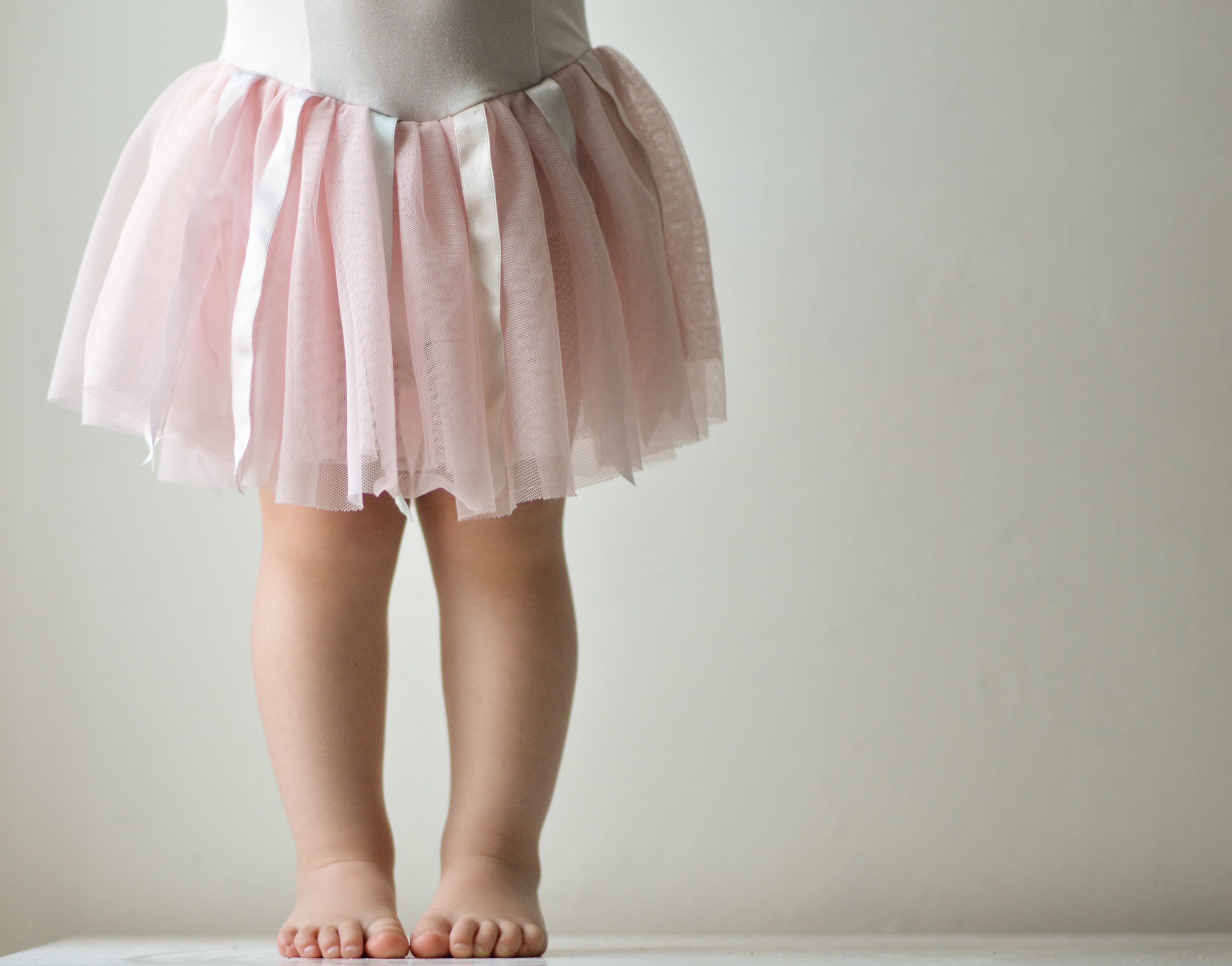 A barefoot child wearing a pink tutu