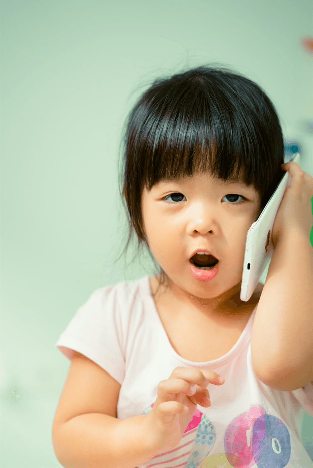 A child holding a phone up to their ear