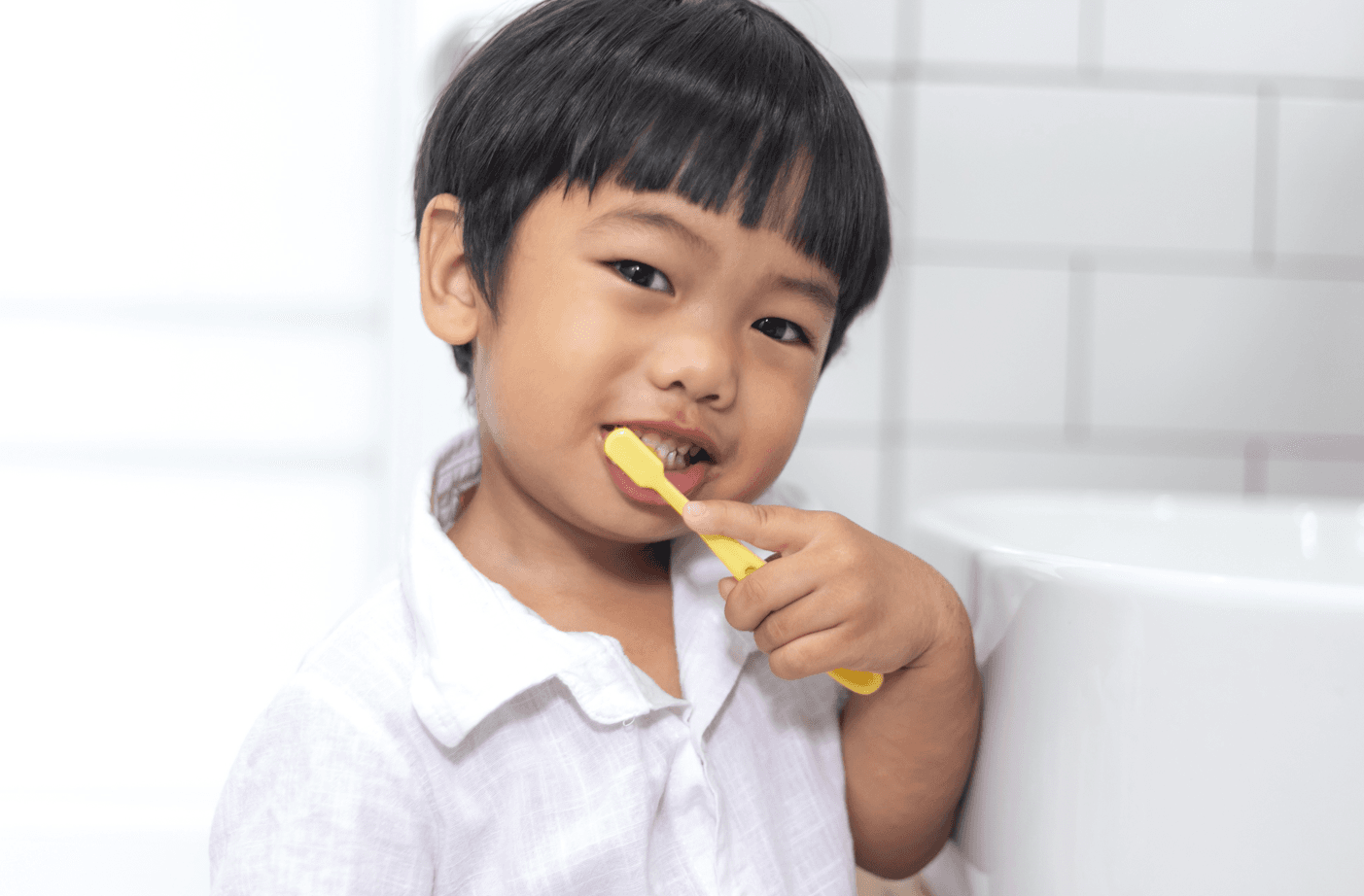 A smiling child brushing their teeth