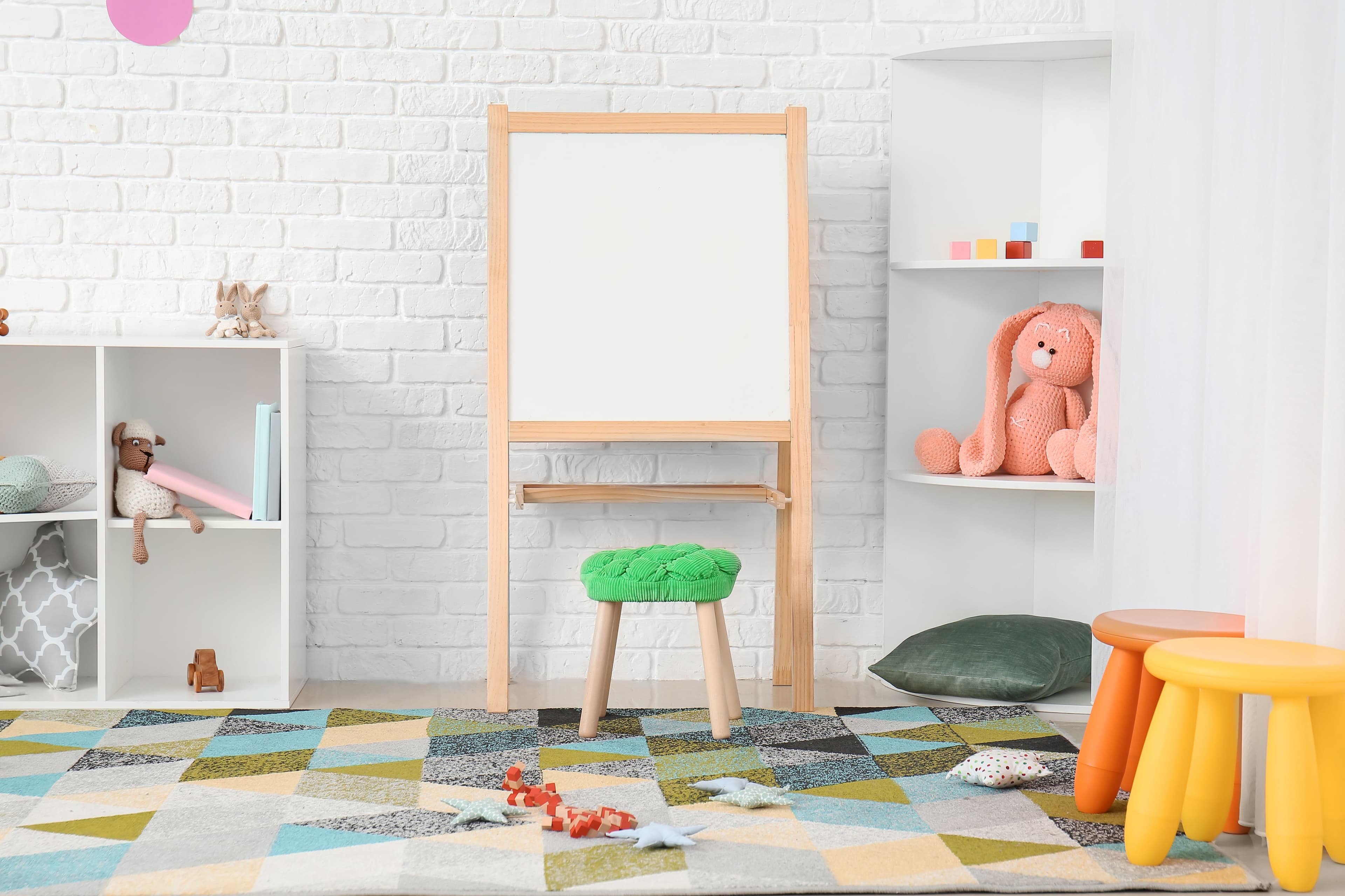 Playroom for kids with eisel and brightly colored furnitur