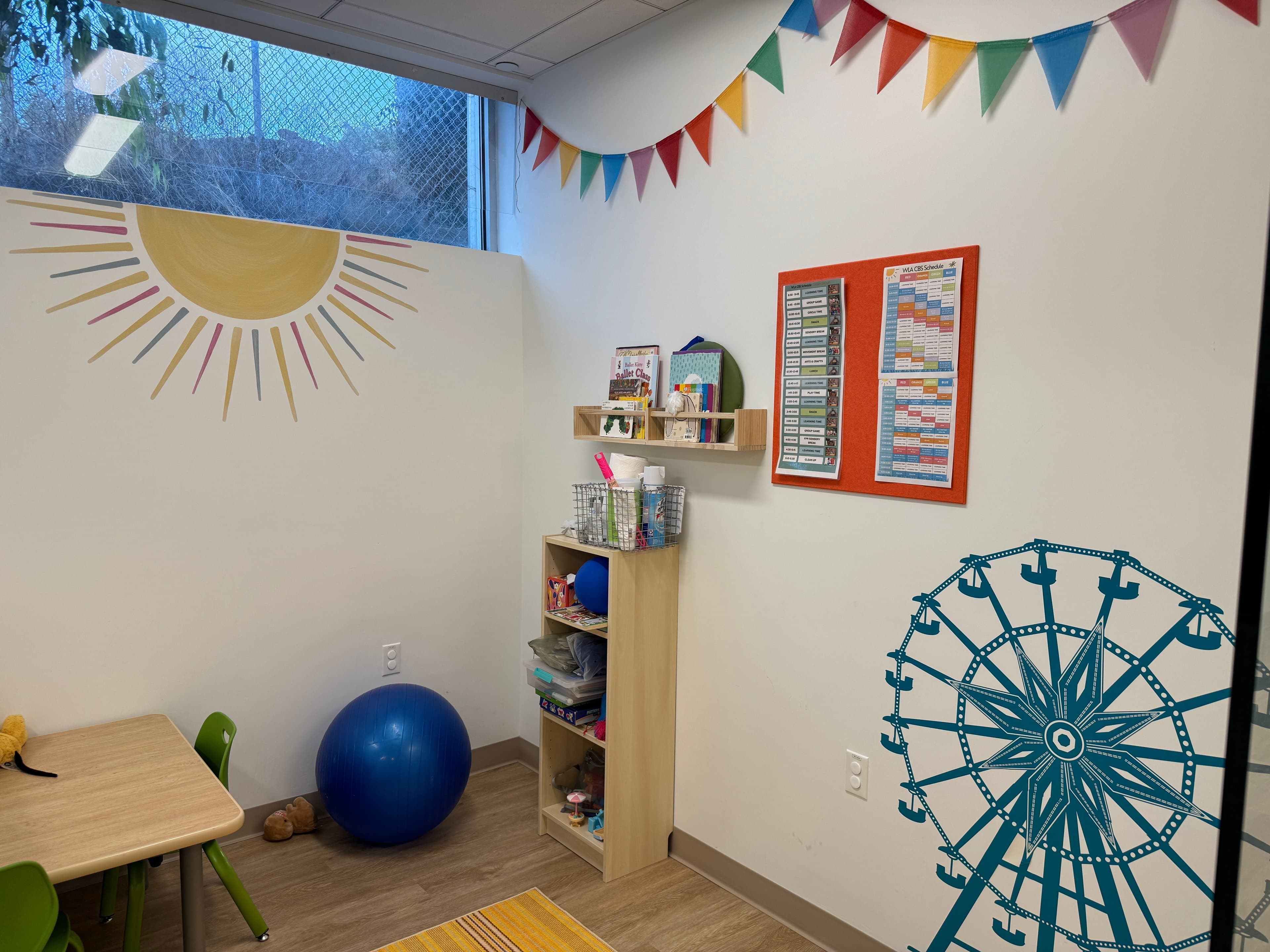 A kids play room with colorful murals on the wall and toys on a shelf