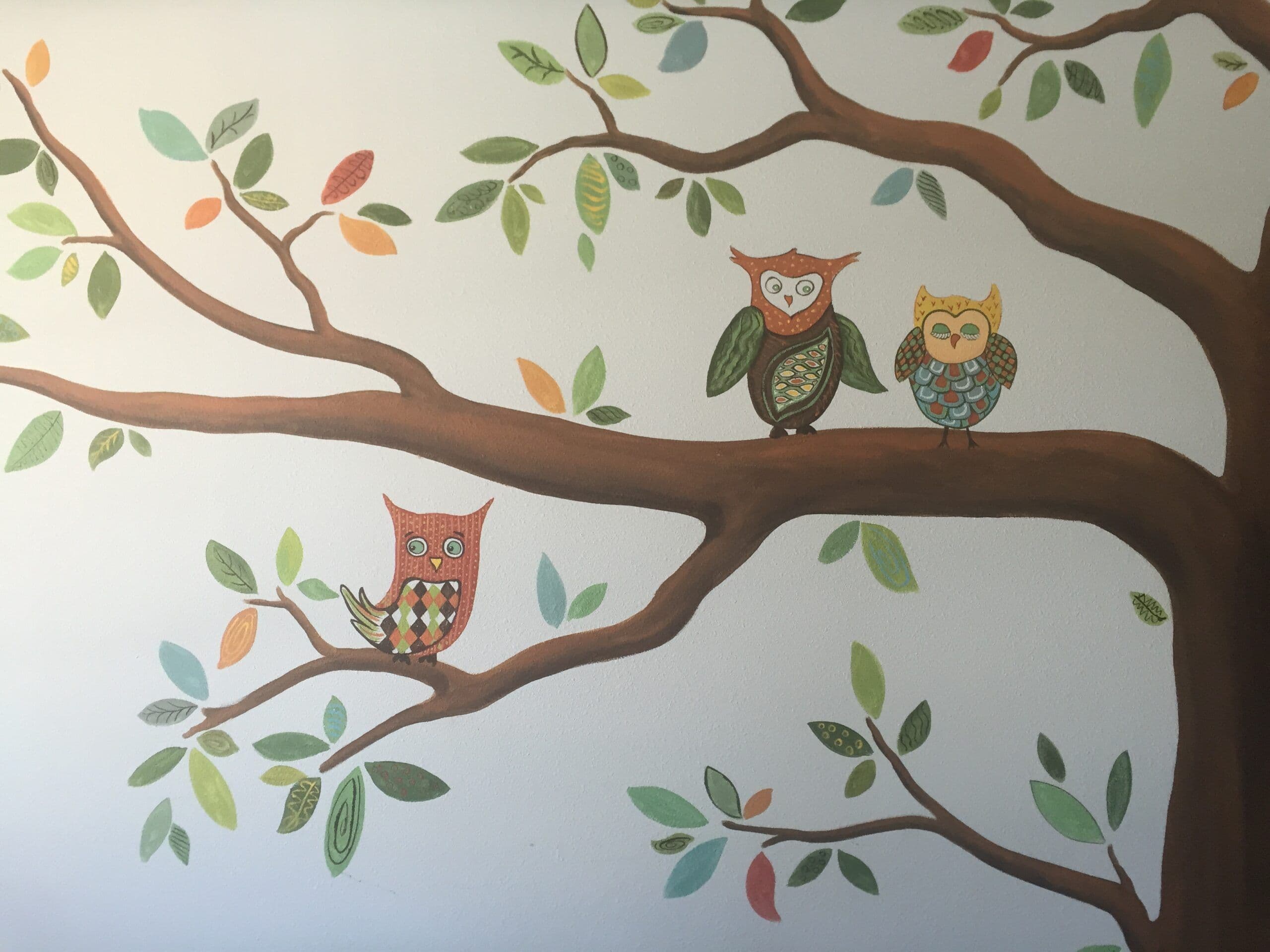 Kids wallpaper with three colorful owls in a tree